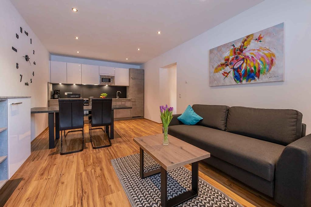 Appartement Naomi - Der Lebensraum des Appartements mit Couch, Esstisch und voll ausgestatteter Küche.